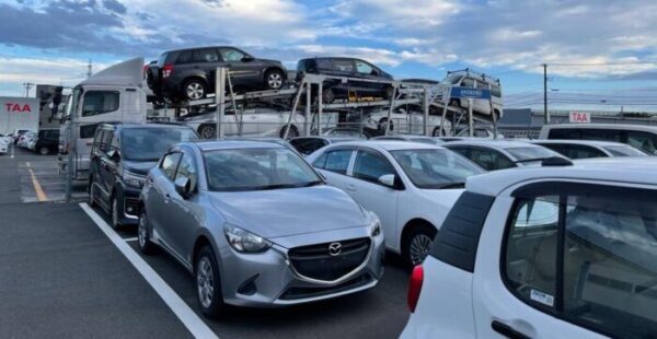 автомобили и автовоз возле аукциона TAA в японии
